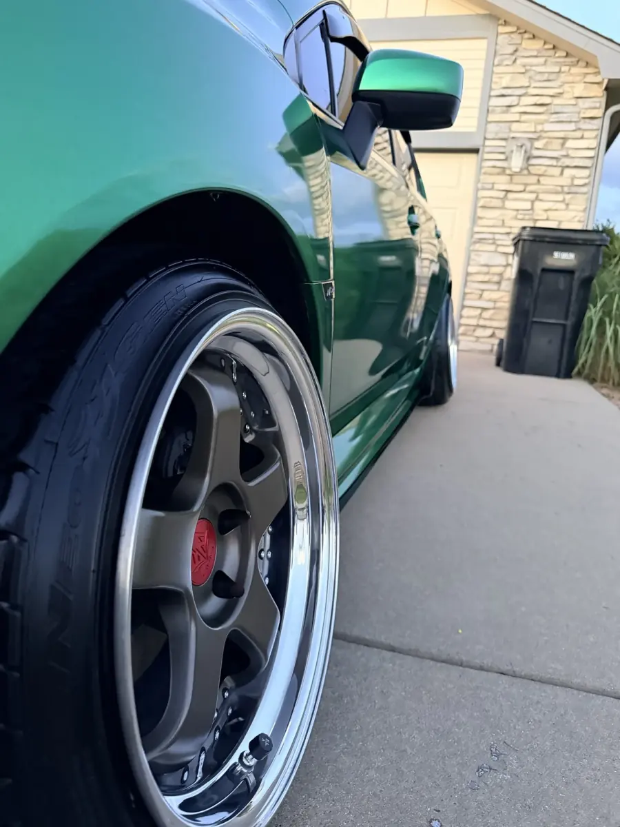 Polished wheel and paintwork on a green coupe