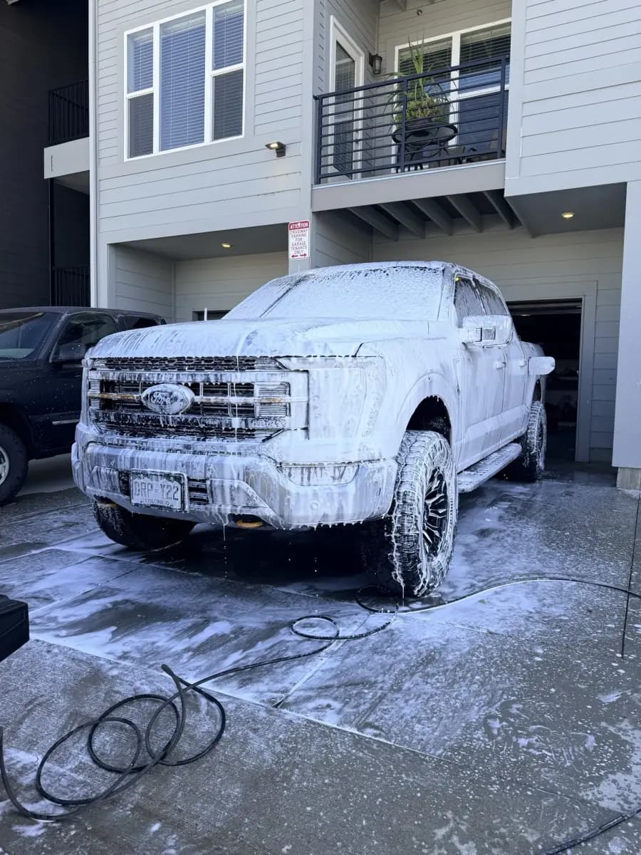 Ford F-150 under a full foam bath in a driveway